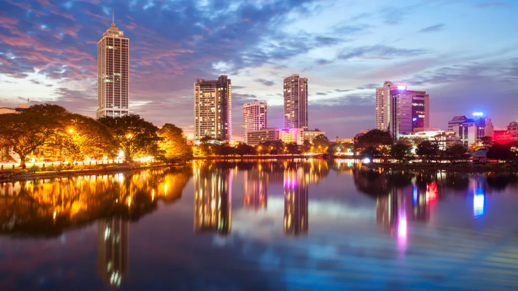 Edificios iluminados reflejados en el lago Beira de Colombo, Sri Lanka
